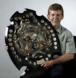 Guy Hansen holding a large trophy shield.